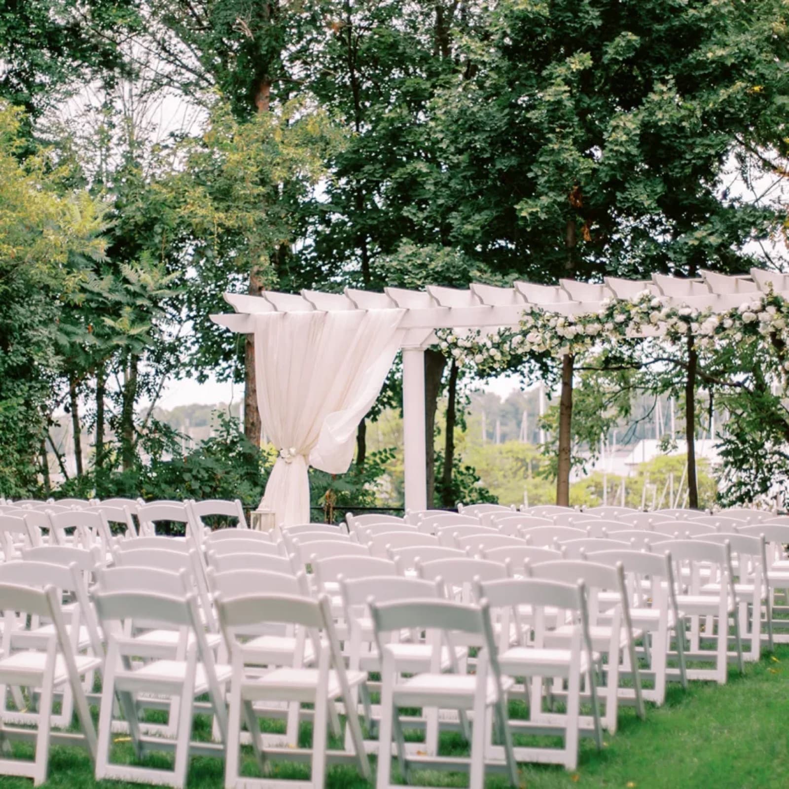 The garden pergola at Queen's Landing, sailboat masts beyond