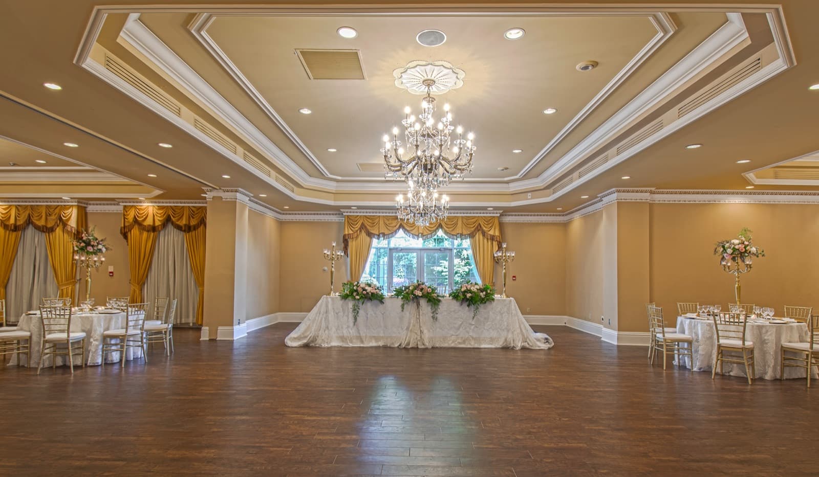 The Imperial Ballroom — chandelier over the dance floor, head table dressed in flowers