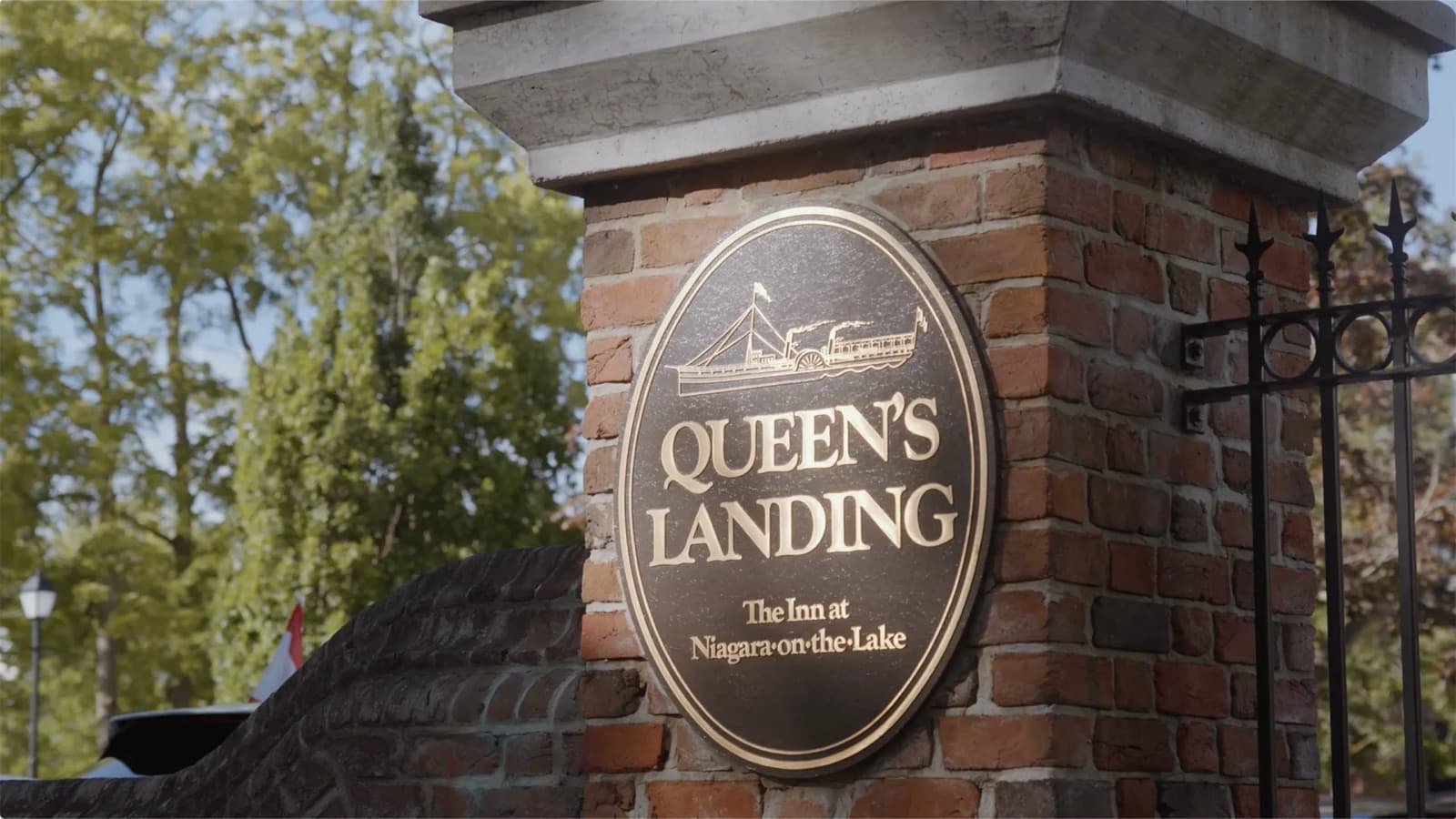 The brass Queen's Landing sign at the gate